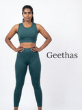 Model wearing teal blue sleeveless cropped activewear top and high-waisted leggings