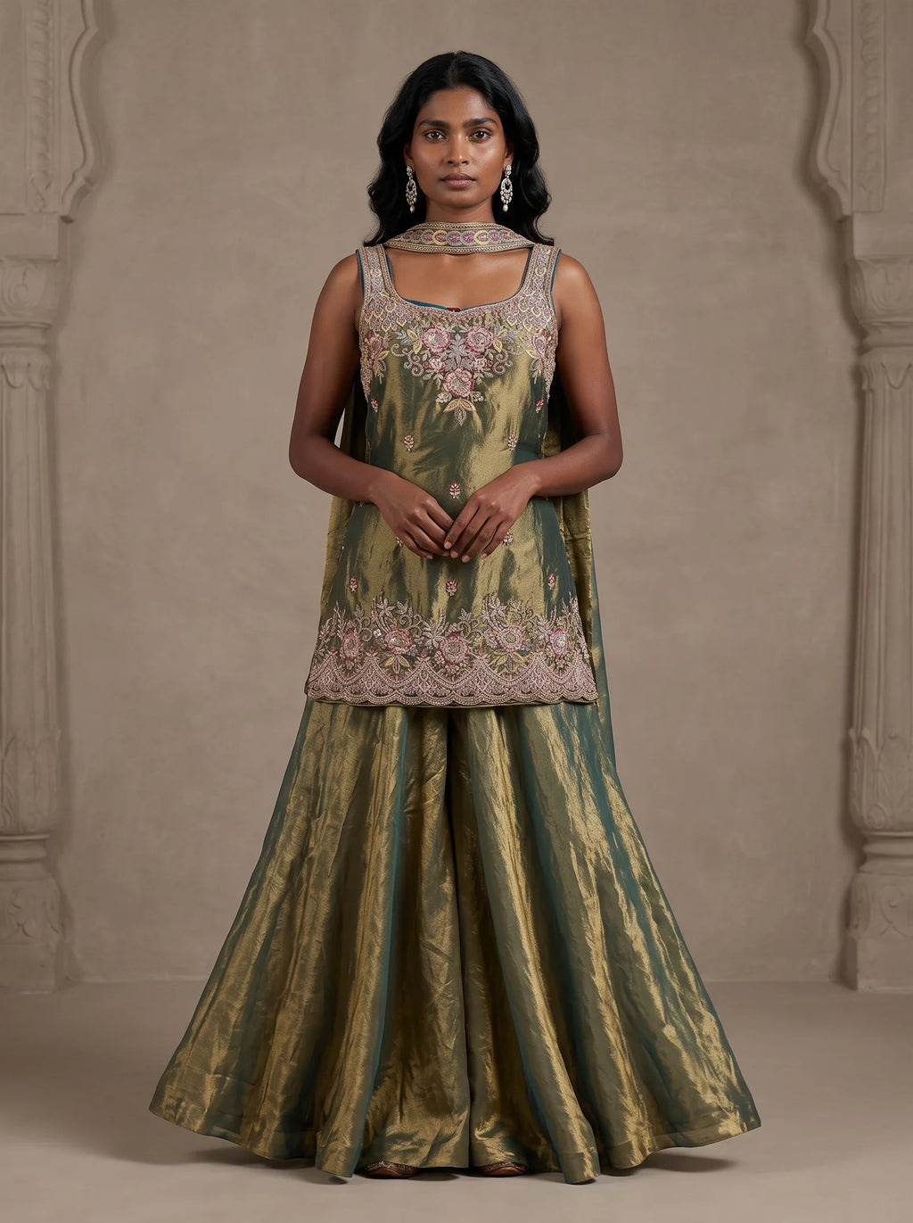 Model wearing olive green tissue silk embroidered sharara set with metallic gold sheen and matching dupatta