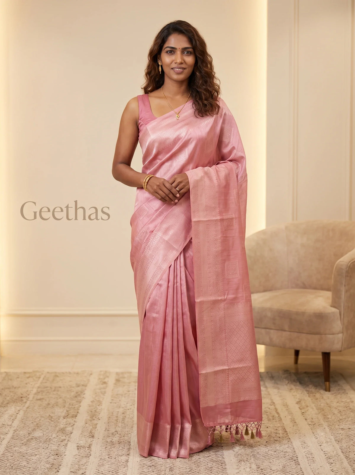 Model wearing pastel pink ready-to-wear soft tissue saree with woven motifs, patterned border and tassled pallu