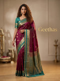 Model wearing magenta soft silk saree with teal and gold-toned woven border and paisley pallu
