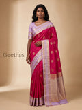 Model wearing a magenta soft silk saree with gold-toned woven motifs and a lavender zari border